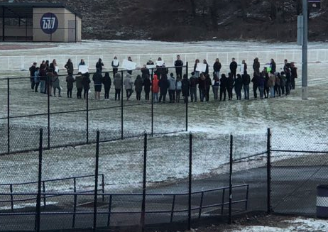 Students gathered on softball field for walkout.