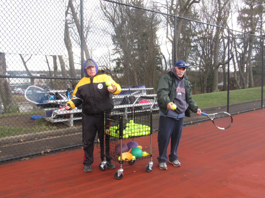 New tennis coaches Tom Kirk (left) and Dave Shenefelt (right) prepare to feed tennis balls to players in warm-ups. The coaches hope to lead their team to playoffs this season.