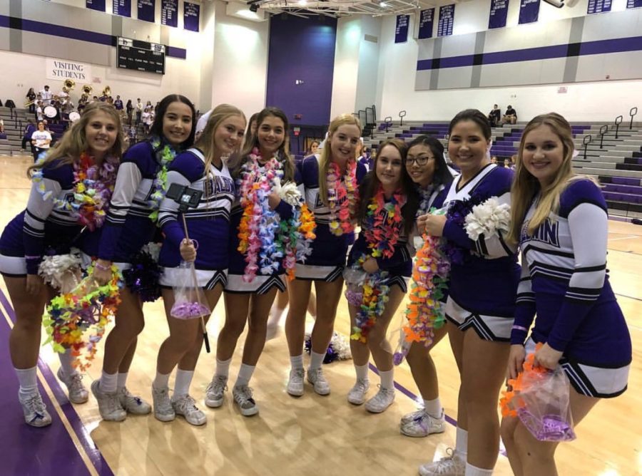 The varsity cheerleaders help pep up students for the football game.
