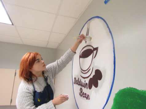 Preparing the Bean: Senior Alexis Primrose paints the inside of the Baldwin Bean. The coffee shop will be open first and second periods.