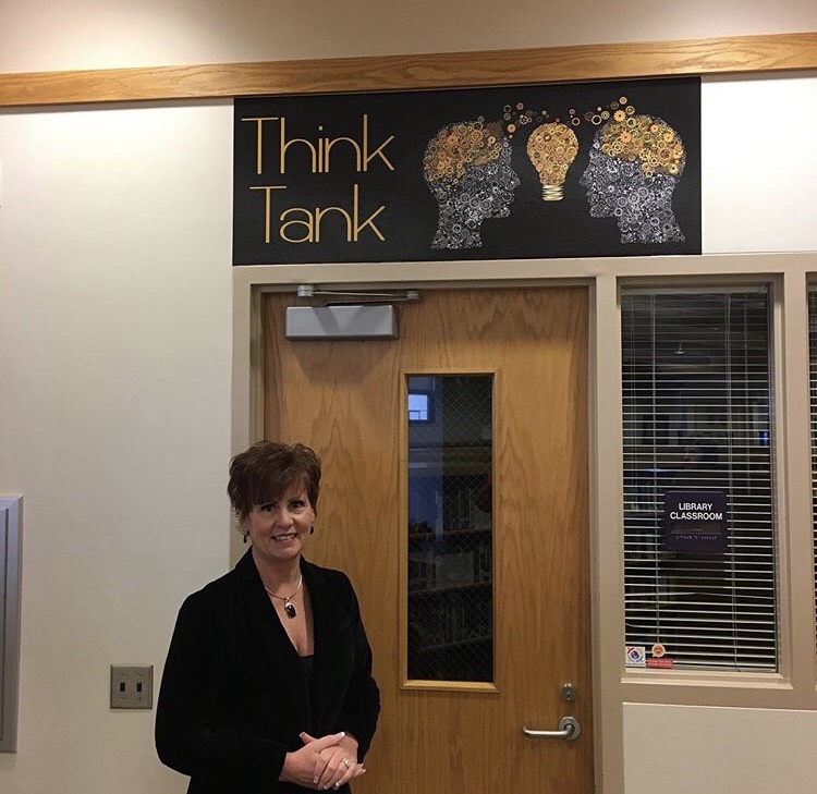 Library Media Specialist Brigetta Del Re stands by the new sign of the Think Tank, a group collaboration room in the library. 