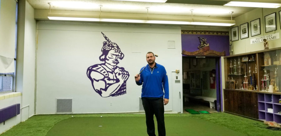 Golf Coach Steve Sinning  stands in the teams practice facility.  The team added a new putting green.