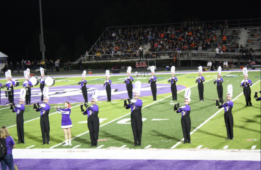 The+marching+band+duo+represents+the+football+and+cheer+teams+by+wearing+their+uniforms+during+halftime.
