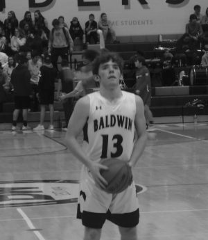 Senior Andy Degenhardt focuses on scoring points at a basketball game before taking a shot. He has played the sport since third grade. 
