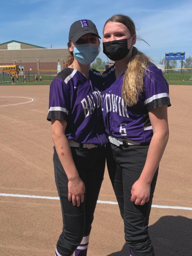 Picture of Grace and Anna Schumacher standing together before their softball game. 