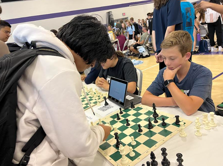 At the Chess Club table, sophomore Carter Smeal challenges an interested student to a chess match. 