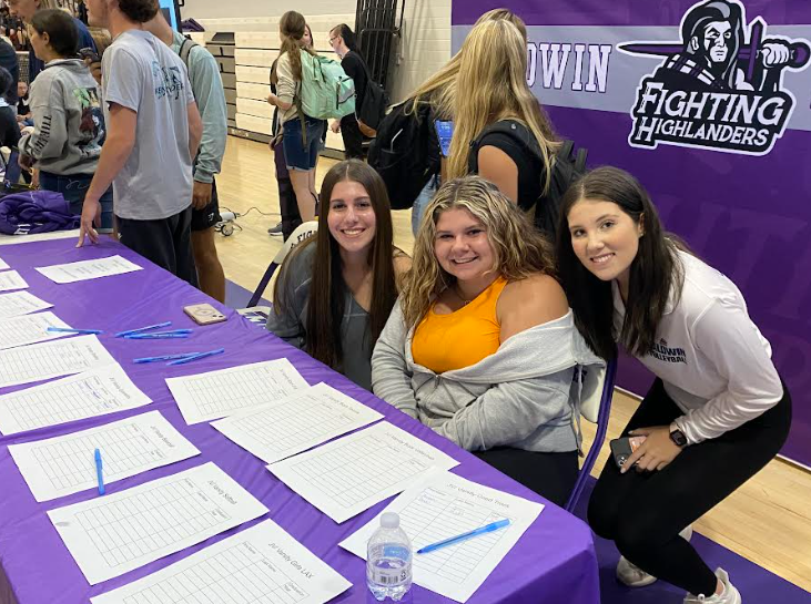Junior Aliza Very and seniors Keira Platz and Katie Oniell represent the Highlander Athletics table. 