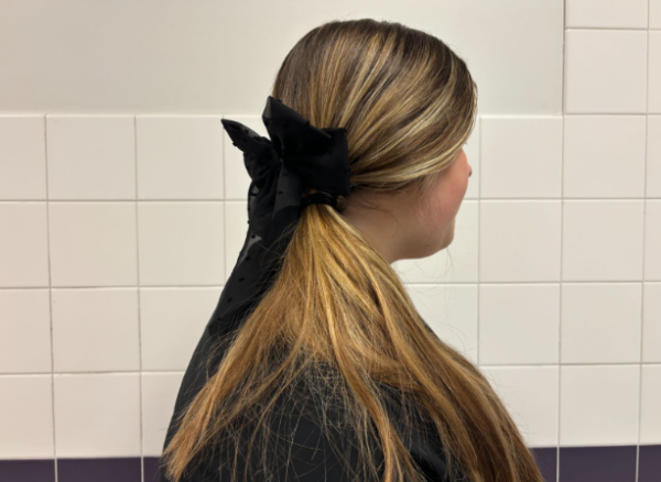 Freshman Gwen Gordon wears a black bow with her outfit. Bows are a resurfaced fashion trend.