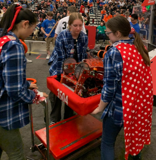 Kameron Locy (center) works with the Carnegie Mellon University Girls of Steel robotics team in the world championship competition in Houston. Photo provided by Kameron Locy.