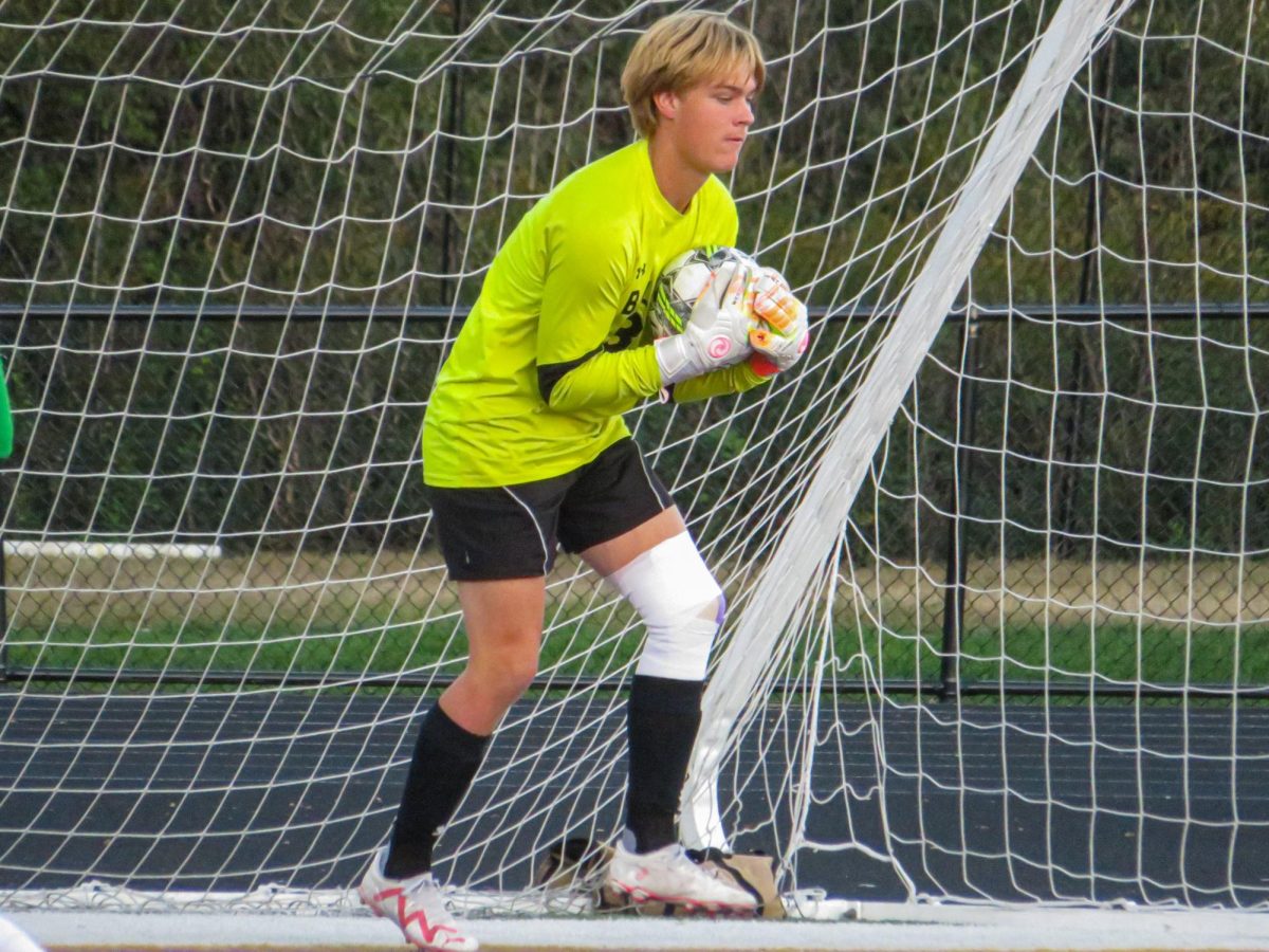 Senior Gabe Herrle saves a shot during warmups against Blackhawk.