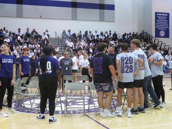 The players talk to each other before musical chairs during the pep rally.