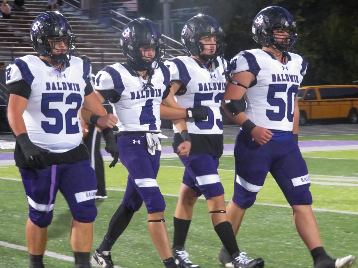 Baldwin’s team captains, seniors Cenzo Pacella, Jaden Duttine, Zachary Zeman, and Dominic Brown, walk out to midfield before the game against Moon.