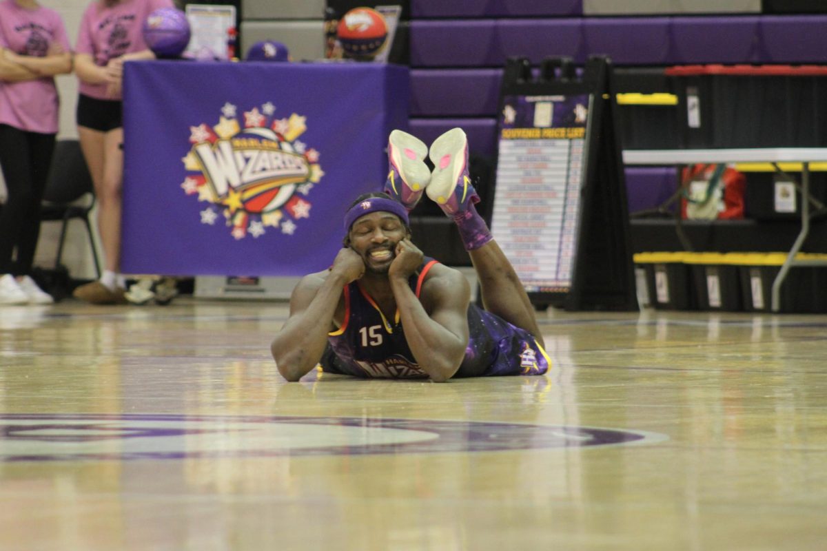 Lloyd Clinton, known as Loonatik, lies on the court during the introductions for the Harlem Wizards game against the Baldwin Staff.