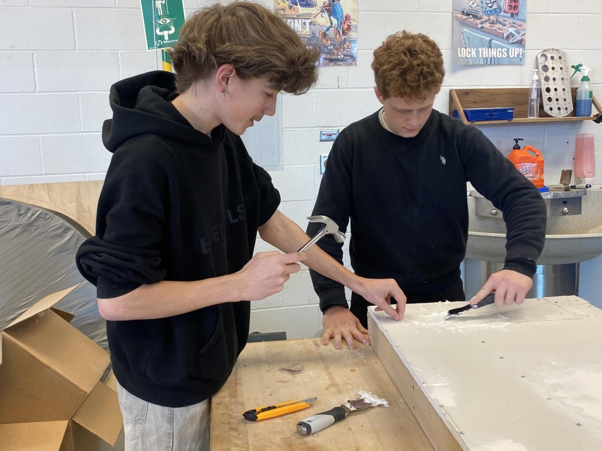 Sophmores Carson Verk (left) and Joey Jackson work on hammering nails into drywall. 