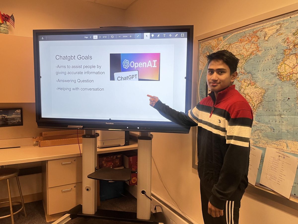 Senior Abishek Sapkota demonstrates what his slides are before presenting to the eighth graders.