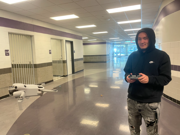 Senior Mason Cerminara flies a drone through the school hallway.
