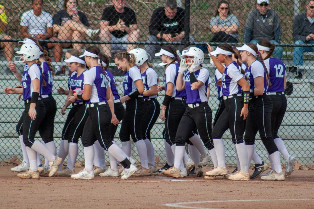The team celebrates with junior Avery Herrington after she hits a home run against Norwin.
