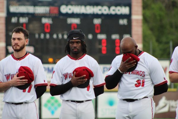 Caleb McNeely (left), Brett Roberts (middle), and Tyreque Reed line up for the national anthem.