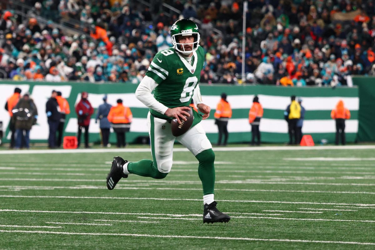 Jan 5, 2025; East Rutherford, New Jersey, USA; Aaron Rodgers (8) runs with the ball during the third quarter of their game against the Miami Dolphins at MetLife Stadium. Mandatory Credit: Ed Mulholland-Imagn Images