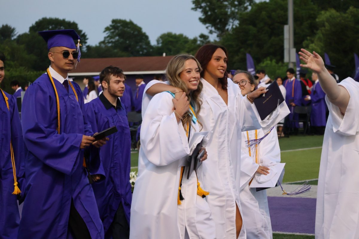 Seniors celebrate after receiving diplomas and tossing their caps.