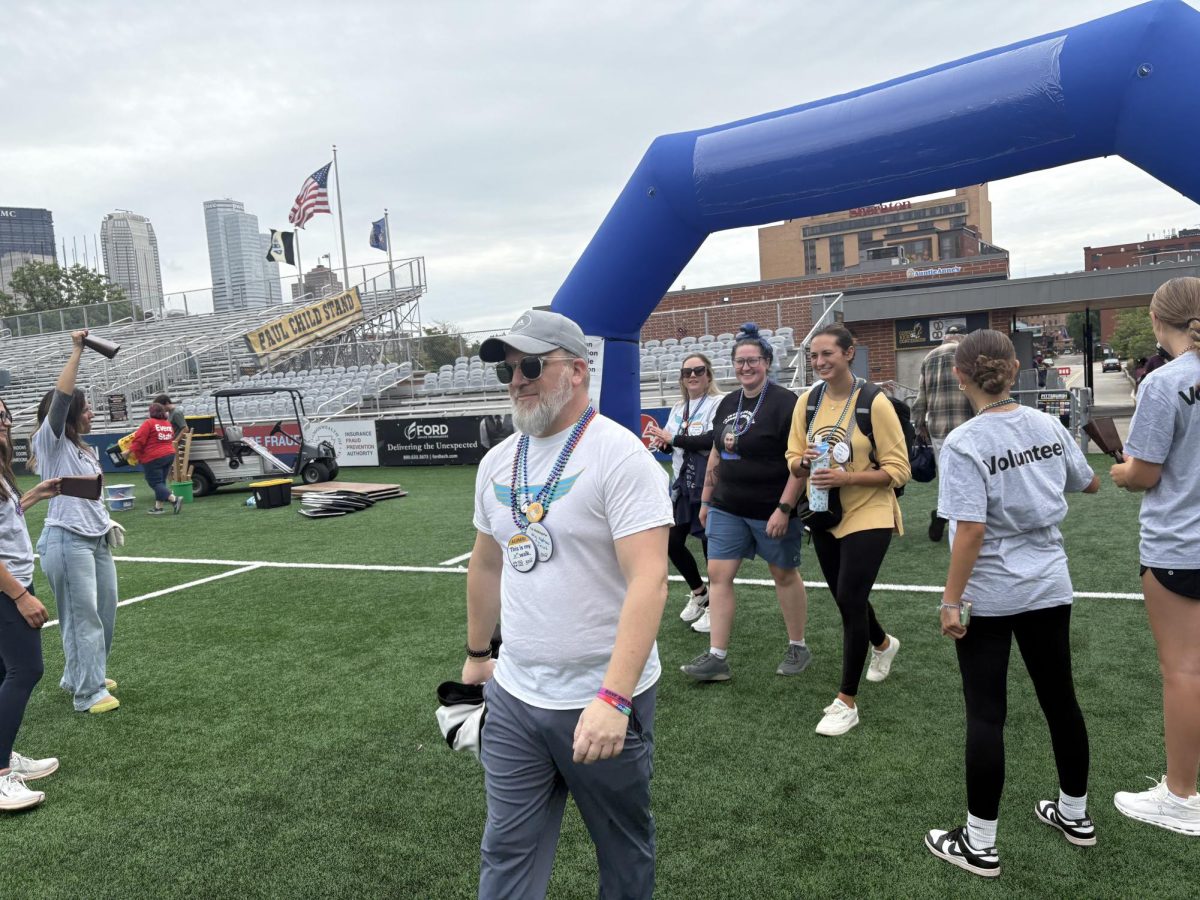 Attendees of the Out of The Darkness Walk finish while volunteers cheer them on. 