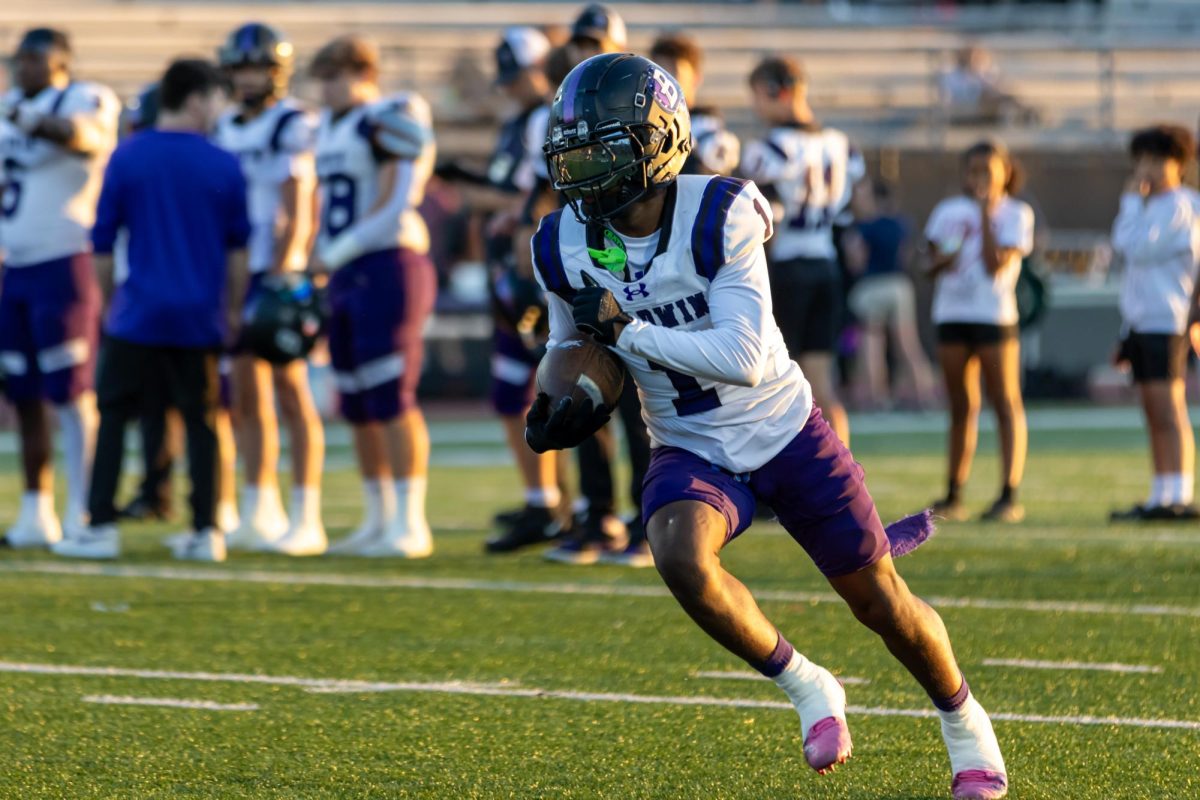 Junior Jourdan Bryant runs the ball towards the end zone during warmups before the game.