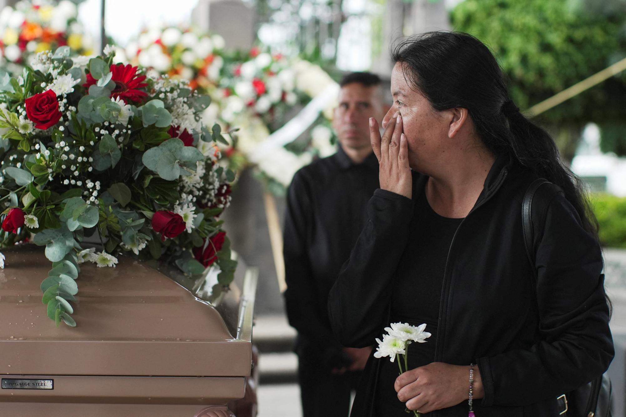 A relative of Silverio Villegas Gonzalez, 38, a man from Michoacan who was fatally shot by a U.S. Immigration and Customs Enforcement (ICE) agent in Franklin Park, Illinois, shortly after dropping off his two children at a nearby elementary school and daycare, wipes away tears while standing next to his casket during a tribute by local authorities in Irimbo, Mexico, September 26, 2025. REUTERS/Ivan Arias