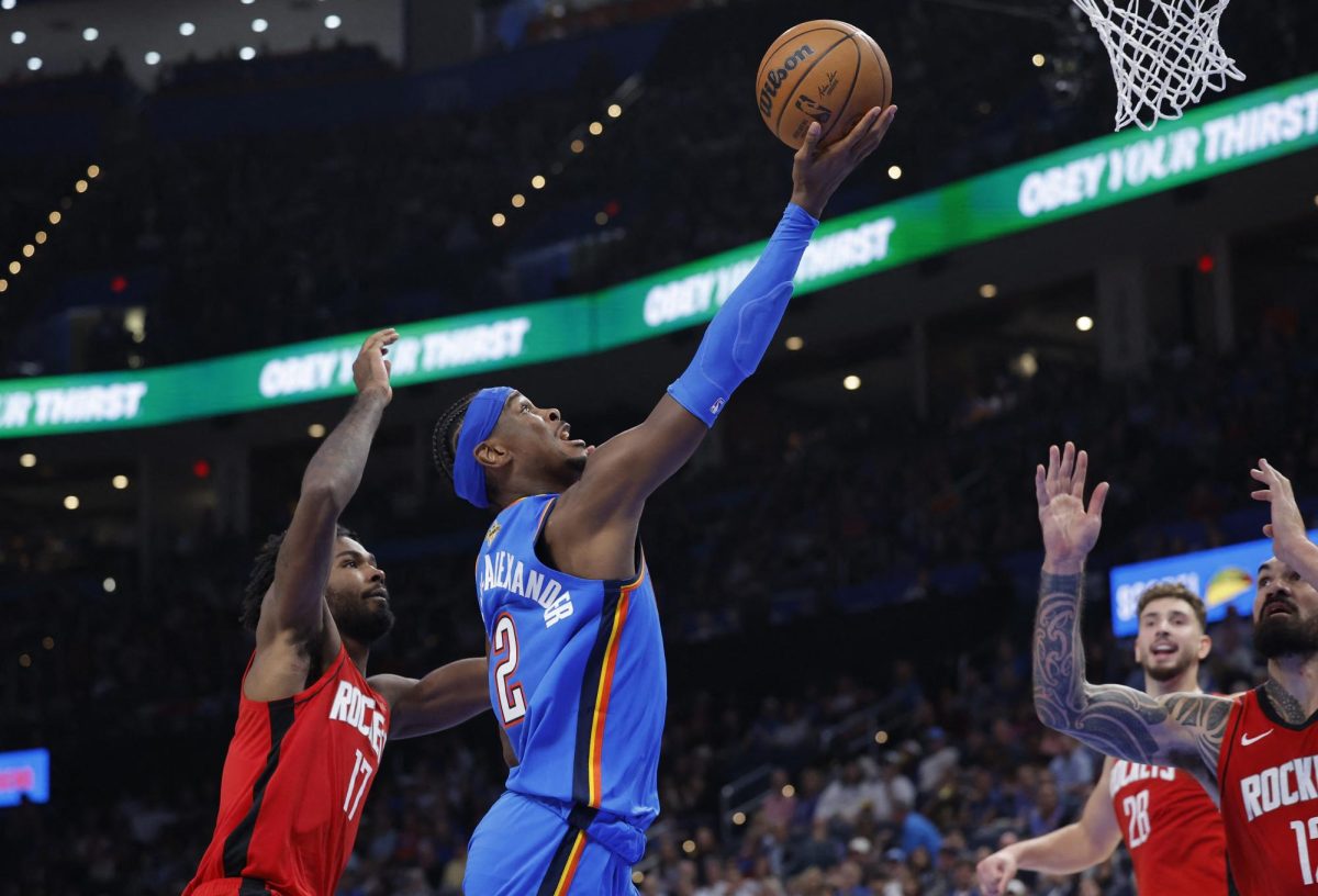 Oct 21, 2025; Oklahoma City, Oklahoma, USA; Oklahoma City Thunder guard Shai Gilgeous-Alexander (2) goes up for a basket between Houston Rockets forward Tari Eason (17) and center Steven Adams (12) during the first half at Paycom Center. Mandatory Credit: Alonzo Adams-Imagn Images