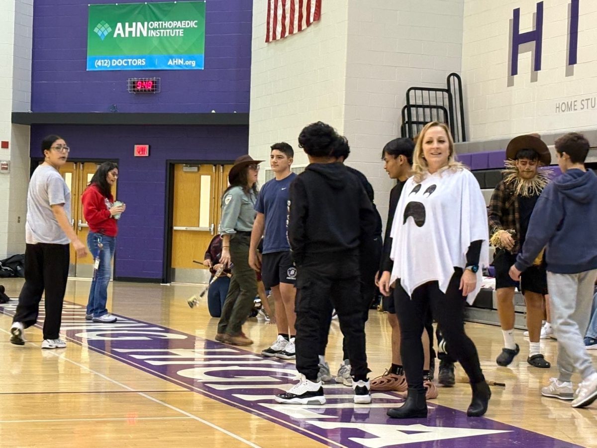 Teams await the start of the broomstick competition during the Halloween games.