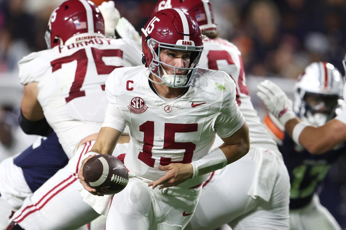 Nov 29, 2025; Auburn, Alabama, USA; Alabama Crimson Tide quarterback Ty Simpson (15) runs with the ball during the first half against the Auburn Tigers at Jordan-Hare Stadium. Mandatory Credit: John Reed-Imagn Images