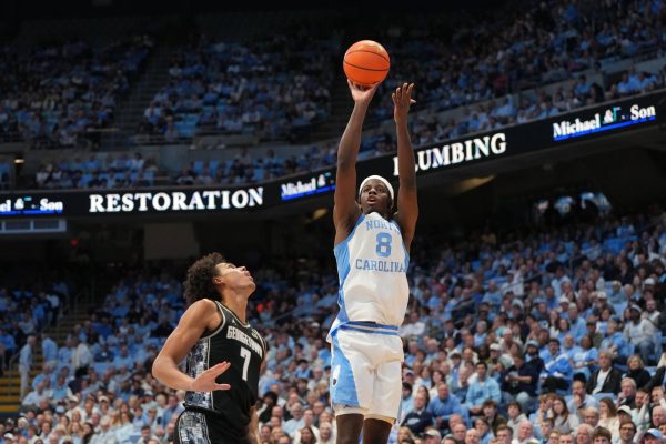 Dec 7, 2025; Chapel Hill, North Carolina, USA;  North Carolina Tar Heels forward Caleb Wilson (8) shoots as Georgetown Hoyas forward Isaiah Abraham (7) defends in the second half at Dean E. Smith Center. Mandatory Credit: Bob Donnan-Imagn Images