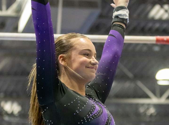 Junior Charlotte Fauls salutes after finishing her bar routine against Tj. 