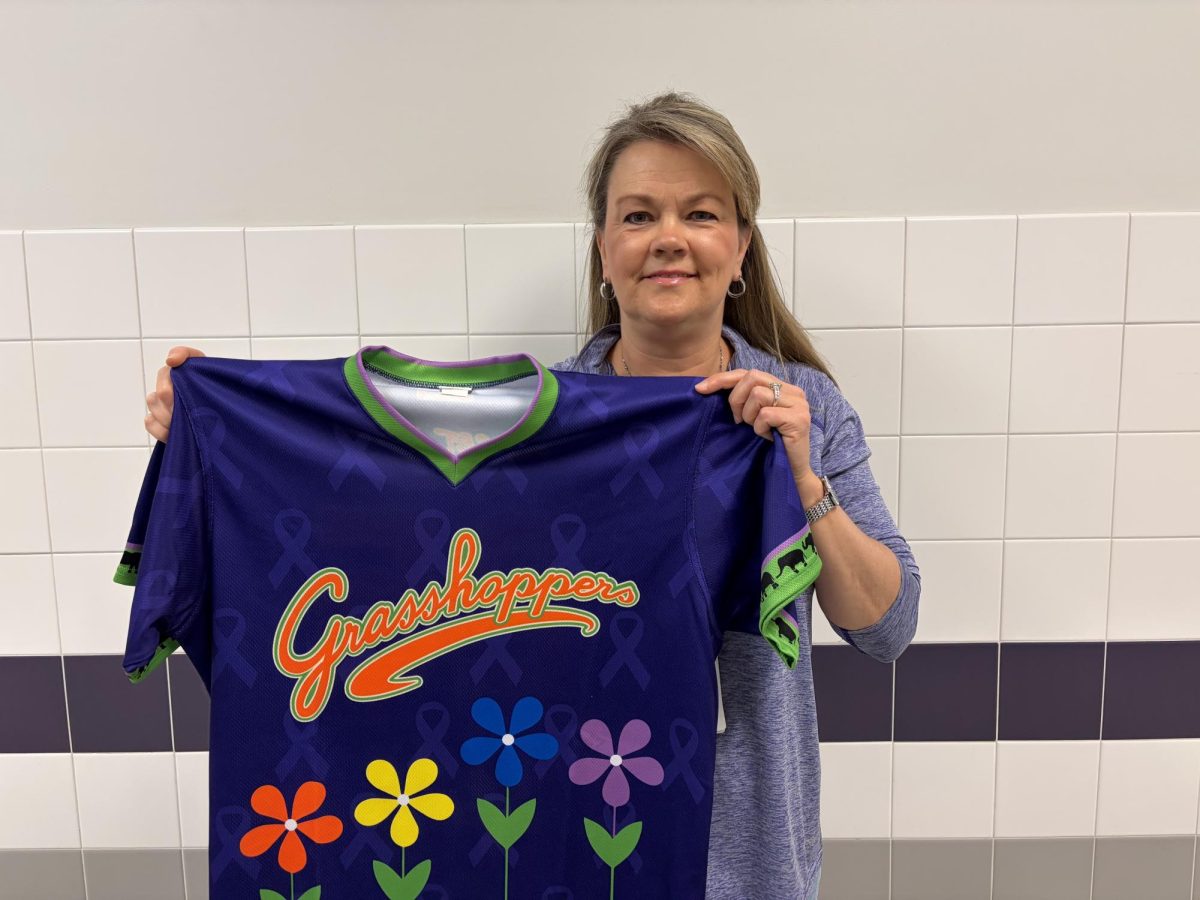 Substitute teacher Leigh Meis holds up one of her son's jerseys.