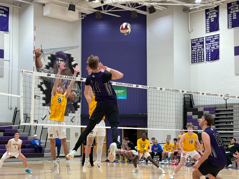 Senior Brayden Gremba kills the ball past two Canon-Mac defenders.